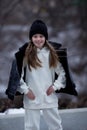 Outdoor autumn portrait of young fashionable happy girl wearing black coat, hat, with black backpack, posing in street of European Royalty Free Stock Photo