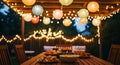 Outdoor backyard dining area with wooden table and colorful lantern string lights at dusk Royalty Free Stock Photo