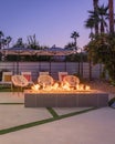 Outdoor backyard patio at night with a fireplace and chairs Royalty Free Stock Photo