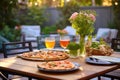 outdoor backyard table setting with grilled pizzas and drinks