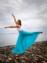 Outdoor ballet practice. Beautiful Caucasian woman practicing ballet pose. Young ballerina wearing long blue skirt, dancing and Royalty Free Stock Photo