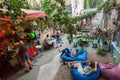 Outdoor bar with group of students relaxing under trees in rustic courtyard