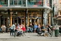 Outdoor bar with happy customers, drinking people with food on old city street