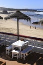 Outdoor bar terrace with straw umbrellas by the shore on Almograve beach