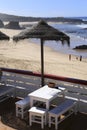 Outdoor bar terrace with straw umbrellas by the shore on Almograve beach