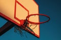 Outdoor basketball board with hoops and torn net in sunset Royalty Free Stock Photo