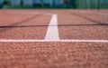 Outdoor Basketball Court Three Point Line. White On Red. Shadows From Fencing, Blurred Green Background