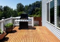 Outdoor BBQ cooker with lid open displaying smoke coming out while on home wooden deck Royalty Free Stock Photo