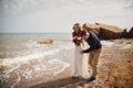 Outdoor beach wedding ceremony near the sea, stylish happy smiling groom and bride are having fun and laughing Royalty Free Stock Photo