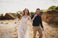 Outdoor beach wedding ceremony near the sea, stylish happy smiling groom and bride are having fun and laughing Royalty Free Stock Photo