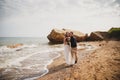 Outdoor beach wedding ceremony near the sea, stylish happy smiling groom and bride are kissing and having fun Royalty Free Stock Photo