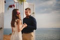 Outdoor beach wedding ceremony, stylish happy smiling groom and bride are standing near wedding altar on the sea shore Royalty Free Stock Photo