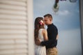 Outdoor beach wedding ceremony, stylish happy smiling groom and bride are standing near wedding altar on the sea shore, hugging Royalty Free Stock Photo