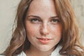 Outdoor beauty. Portrait of smiling young and happy woman with freckles. Royalty Free Stock Photo