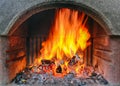 Outdoor brick fireplace with a fire blazing inside