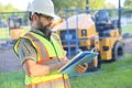 Outdoor builder portrait, construction man worker standing with blueprints