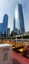 Outdoor cafe with seats by the Riverwalk of Chicago River with urban and skyscrapers, vertical shot