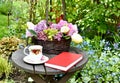 Afternoon tea outdoors in spring flower garden with English tea in fancy teacups
