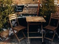 Outdoor cafe on street decorated and illuminated for Christmas. Table, two chairs, plaque with inscription Take Away, retro lamp, Royalty Free Stock Photo