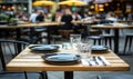 Outdoor Cafe Table Setting with Blurred Patrons Royalty Free Stock Photo