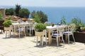 Outdoor cafe with tables and chairs on the outdoor terrace overlooking the blue sea Royalty Free Stock Photo
