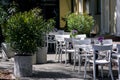 Outdoor cafe terrace with white wooden chairs and tables. Royalty Free Stock Photo