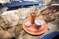 Outdoor cafe with turkish coffee in copper cezve and a piece of turkish delight on the glass table