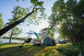 Outdoor camping tent with tarp or flysheet on green grass and light morning. Royalty Free Stock Photo