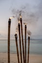 Outdoor candles burning on bamboo sticks