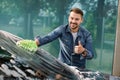 Outdoor car wash with sponge and foam. Car washing. Smiling bearded man showing thumb up, cleaning his car windscreen Royalty Free Stock Photo