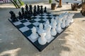 Outdoor Chess Game at Big Chequer Board. Super big size of black and white chess game pieces Royalty Free Stock Photo