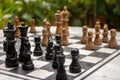 Outdoor chessboard with black and yellow figures with unfocused background. Competition and strategy concept. Intelligent sport. Royalty Free Stock Photo