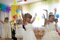 Outdoor children party in kindergarten. Little girls are dancing on holiday