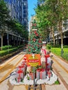 Outdoor Christmas Greeting Wishes Decoration with tree and gift boxes with ribbon, lining green trees & park in Mont Kiara Arcoris Royalty Free Stock Photo