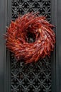 Outdoor Christmas wreath made of dried red hot chili peppers hanging at entrance door Royalty Free Stock Photo