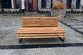 Outdoor city architecture, wooden bench on city street, urban public furniture. Comfortable bench in recreation area Royalty Free Stock Photo