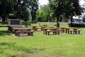 Outdoor classroom with blackboard tables and benches made from strong wooden logs in public park surrounded with grass and trees