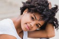 Outdoor close-up portrait of beautiful brunette young dark-skinned woman with curly  hairstyle smiling cheerful to camera while Royalty Free Stock Photo