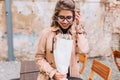 Outdoor close-up portrait of beautiful girl inhales flower fragrance on a date in a cafe. Charming embarrassed young Royalty Free Stock Photo