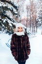 Outdoor close up portrait of young beautiful fashionable woman with afro hair , wearing fur coat in winter park. Winter fashion, Royalty Free Stock Photo