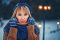 Outdoor close up portrait of young beautiful girl with long blond hair wearing knitted scarf, hat, mittens and sweater Royalty Free Stock Photo