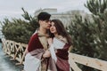 Outdoor close up portrait of young beautiful happy smiling couple bundled up in tartan blanket. Christmas, new year Royalty Free Stock Photo