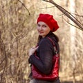 Outdoor close up portrait of young beautiful happy smiling girl wearing french style red knitted beret Royalty Free Stock Photo