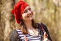 Outdoor close up portrait of young beautiful happy smiling girl wearing french style red knitted beret Royalty Free Stock Photo