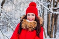 Outdoor close-up portrait of young beautiful happy smiling girl wearing red knitted hat, and coat . Royalty Free Stock Photo