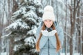 Outdoor close-up portrait of young beautiful happy smiling girl, wearing stylish knitted winter hat and gloves. Model expressing j Royalty Free Stock Photo