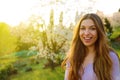 Outdoor close up portrait of young beautiful happy smiling woman with long hair posing near blooming tree. Copy, empty space for Royalty Free Stock Photo