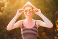 Outdoor close up portrait of young beautiful happy smiling woman wearing sunglasses, straw hat, posing in forest. Royalty Free Stock Photo
