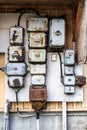 Outdoor closeup facade view of many old rusty worn electrical boxes and wires on building wall. Royalty Free Stock Photo