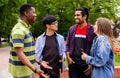 Outdoor communication between joyful multiracial college students Royalty Free Stock Photo